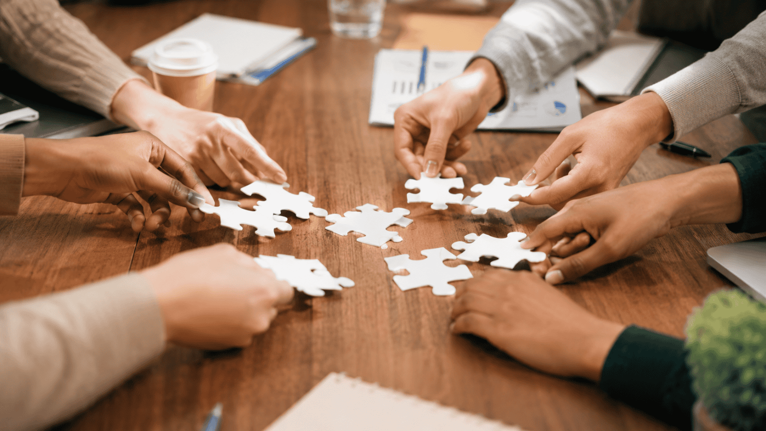 Nonprofit partners working together on a collaborative grant application represented by hands assembling puzzle pieces.